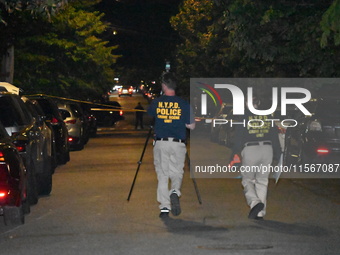 Crime scene investigators collect evidence at the scene where a man is killed by a shot to the head in Queens, New York, on September 11, 20...