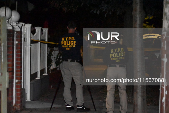 Crime scene investigators collect evidence at the scene where a man is killed by a shot to the head in Queens, New York, on September 11, 20...