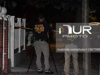 Crime scene investigators collect evidence at the scene where a man is killed by a shot to the head in Queens, New York, on September 11, 20...