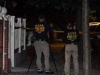 Crime scene investigators collect evidence at the scene where a man is killed by a shot to the head in Queens, New York, on September 11, 20...