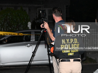 Crime scene investigators collect evidence at the scene where a man is killed by a shot to the head in Queens, New York, on September 11, 20...