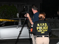 Crime scene investigators collect evidence at the scene where a man is killed by a shot to the head in Queens, New York, on September 11, 20...