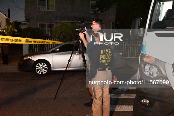 Crime scene investigators collect evidence at the scene where a man is killed by a shot to the head in Queens, New York, on September 11, 20...