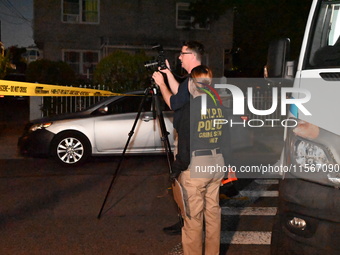 Crime scene investigators collect evidence at the scene where a man is killed by a shot to the head in Queens, New York, on September 11, 20...