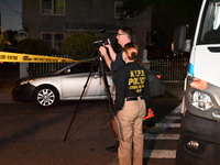 Crime scene investigators collect evidence at the scene where a man is killed by a shot to the head in Queens, New York, on September 11, 20...