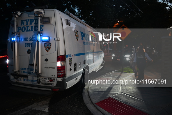 Crime scene investigators collect evidence at the scene where a man is killed by a shot to the head in Queens, New York, on September 11, 20...