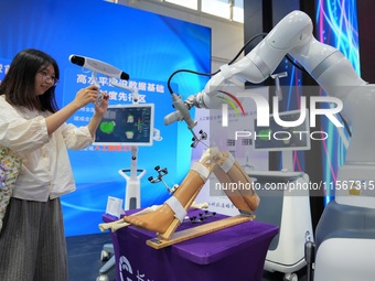 A viewer takes a photo of an artificial intelligence complete orthopedic digital solution at the 2024 China Beijing International Fair for T...