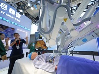 An exhibitor introduces a surgical robot to a visitor at the 2024 China Beijing International Fair for Trade in Services (CIFTIS) in Beijing...