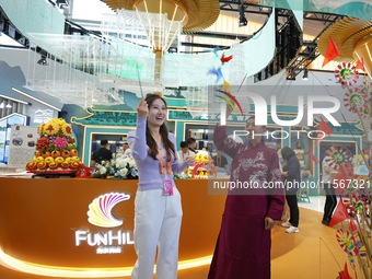 Visitors experience the traditional Beijing toy ''Swallow Windmill'' at the Cultural and Tourism Service exhibition area at the China Beijin...