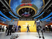 Spectators watch a humanoid robot perform at the China Beijing International Fair for Trade in Services (CIFTIS) in Beijing, China, on Septe...