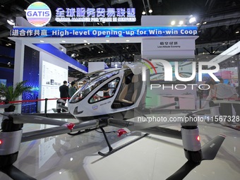 Spectators watch an unmanned electric vertical take-off and landing (VTOL) aircraft at the China Beijing International Fair for Trade in Ser...