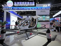 Spectators watch an unmanned electric vertical take-off and landing (VTOL) aircraft at the China Beijing International Fair for Trade in Ser...