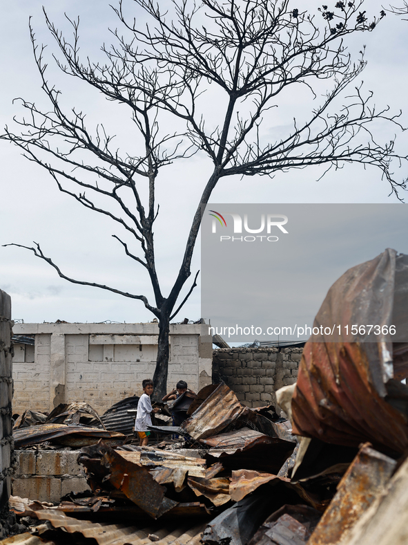 Children help remove the debris of damaged houses following a huge fire that engulfs at least 800 houses in Bacoor, Cavite, the Philippines,...