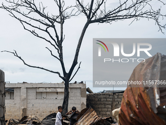 Children help remove the debris of damaged houses following a huge fire that engulfs at least 800 houses in Bacoor, Cavite, the Philippines,...