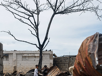 Children help remove the debris of damaged houses following a huge fire that engulfs at least 800 houses in Bacoor, Cavite, the Philippines,...