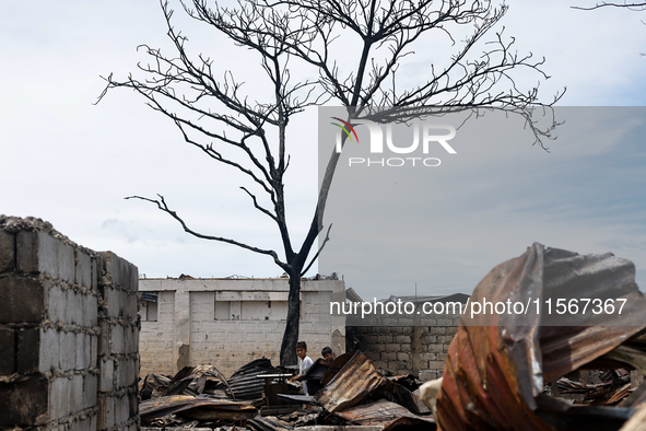 Children help remove the debris of damaged houses following a huge fire that engulfs at least 800 houses in Bacoor, Cavite, the Philippines,...