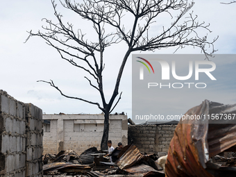 Children help remove the debris of damaged houses following a huge fire that engulfs at least 800 houses in Bacoor, Cavite, the Philippines,...