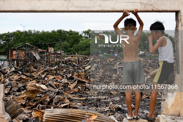 Two children survey the rubble of damaged houses following a huge fire that engulfs at least 800 houses in Bacoor, Cavite, the Philippines,...