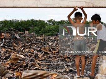 Two children survey the rubble of damaged houses following a huge fire that engulfs at least 800 houses in Bacoor, Cavite, the Philippines,...