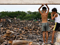 Two children survey the rubble of damaged houses following a huge fire that engulfs at least 800 houses in Bacoor, Cavite, the Philippines,...