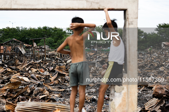 Two children survey the rubble of damaged houses following a huge fire that engulfs at least 800 houses in Bacoor, Cavite, the Philippines,...