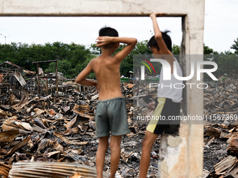 Two children survey the rubble of damaged houses following a huge fire that engulfs at least 800 houses in Bacoor, Cavite, the Philippines,...