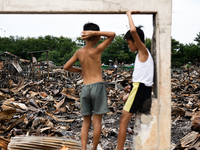 Two children survey the rubble of damaged houses following a huge fire that engulfs at least 800 houses in Bacoor, Cavite, the Philippines,...