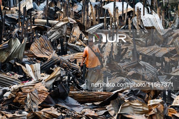 A man looks for salvageable items among the rubble of damaged houses following a huge fire that engulfs at least 800 houses in Bacoor, Cavit...