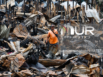 A man looks for salvageable items among the rubble of damaged houses following a huge fire that engulfs at least 800 houses in Bacoor, Cavit...