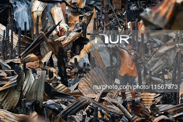 A man looks for salvageable items among the rubble of damaged houses following a huge fire that engulfs at least 800 houses in Bacoor, Cavit...