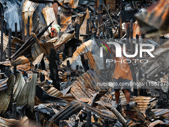 A man looks for salvageable items among the rubble of damaged houses following a huge fire that engulfs at least 800 houses in Bacoor, Cavit...