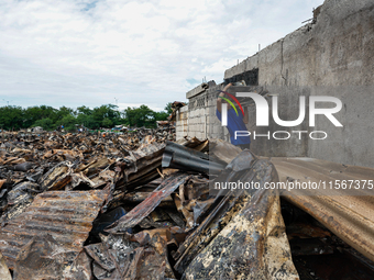 In Bacoor, Cavite, the Philippines, on September 12, 2024, a man carries burnt iron sheets from the rubble of damaged houses following a hug...