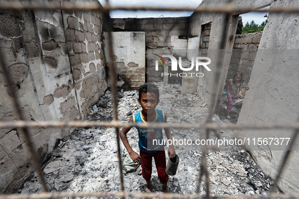 Children search for salvageable items from the rubble of a damaged house following a fire that engulfed at least 800 houses in Bacoor, Cavit...