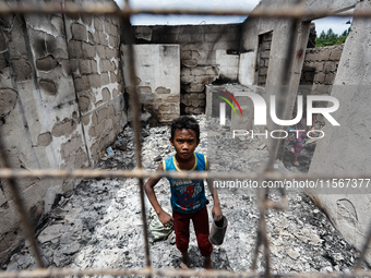 Children search for salvageable items from the rubble of a damaged house following a fire that engulfed at least 800 houses in Bacoor, Cavit...