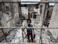 Children search for salvageable items from the rubble of a damaged house following a fire that engulfed at least 800 houses in Bacoor, Cavit...