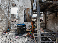 A boy sits on a burnt metal bunk bed inside a damaged house following a huge fire that engulfs at least 800 houses in Bacoor, Cavite, the Ph...