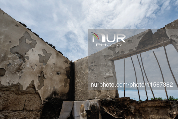 A plane takes off, seen through the collapsed rooftop of damaged houses, following a fire that engulfs at least 800 houses in Bacoor, Cavite...