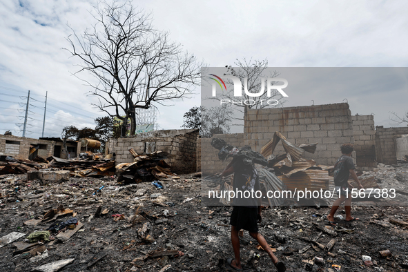 People look for salvageable items among the rubble of damaged houses following a huge fire that engulfs at least 800 houses in Bacoor, Cavit...