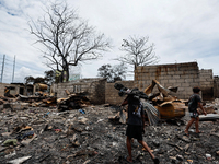 People look for salvageable items among the rubble of damaged houses following a huge fire that engulfs at least 800 houses in Bacoor, Cavit...