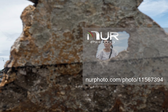 A woman searches for salvageable items among the rubble of damaged houses in Bacoor, Cavite, the Philippines, on September 12, 2024, followi...