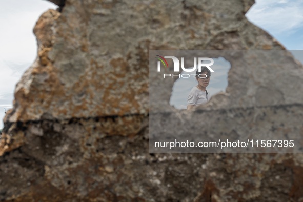 A woman searches for salvageable items among the rubble of damaged houses in Bacoor, Cavite, the Philippines, on September 12, 2024, followi...