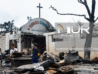 Children help remove the debris of damaged houses following a huge fire that engulfs at least 800 houses in Bacoor, Cavite, the Philippines,...