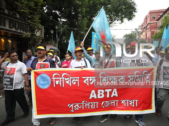 Members of the All Bengal Teachers Association, a teacher's movement in the Indian state of West Bengal, shout slogans during a protest rall...