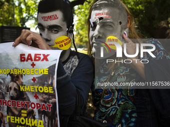 People wear masks of the mayor of Sofia and employees of the municipal shelters for stray dogs in front of the building of the Metropolitan...