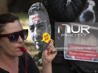 People wear masks of the mayor of Sofia and employees of the municipal shelters for stray dogs in front of the building of the Metropolitan...