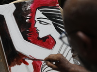 An artist paints a canvas to protest an art camp at the roadside during a protest against the rape and murder of a PGT woman doctor at the g...