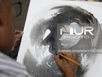 An artist paints a canvas to protest an art camp at the roadside during a protest against the rape and murder of a PGT woman doctor at the g...