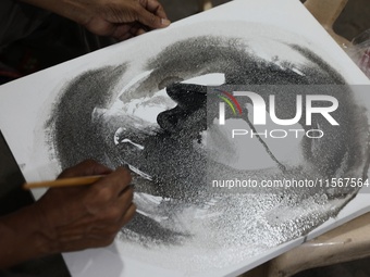 An artist paints a canvas to protest an art camp at the roadside during a protest against the rape and murder of a PGT woman doctor at the g...