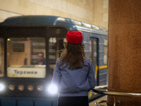 A Kyiv Metro worker stands on the platform of the Demiivska metro station after the traffic relaunches following nine months of repairs in t...