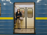 A passenger is on the train at the Demiivska metro station after the traffic is launched following nine months of repairs in the tunnel betw...